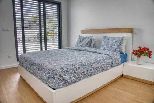ein Schlafzimmer mit einem großen Bett mit Fenster in der Unterkunft Casa PoliDouro - Vila Marim in Vila Marim