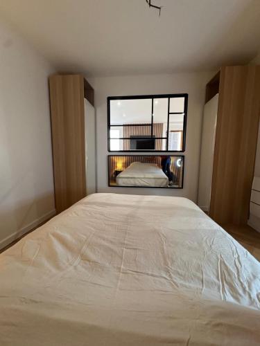 un grand lit dans une chambre avec une grande fenêtre dans l'établissement Chic appartement climatisé La Ciotat, à La Ciotat
