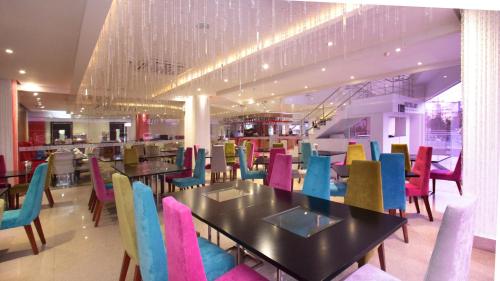 a dining room with tables and colorful chairs at Radisson Diamond Barranquilla in Barranquilla