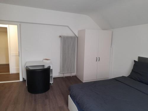 a bedroom with a bed and a desk in it at Bed & Breakfest Wohlen AG Central in Wohlen