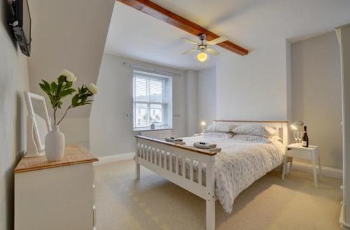 ein Schlafzimmer mit einem Bett und einem Deckenventilator in der Unterkunft Northfield Cottage in Ilfracombe