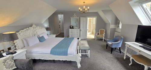 a bedroom with a bed and a desk and a tv at Shendish Manor Hotel & Golf Course in Hemel Hempstead