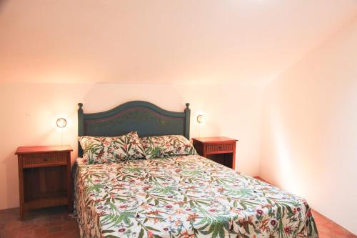 1 dormitorio con 1 cama con 2 mesitas de noche y 2 mesas en Villa Tomada Da Luz, en Areas