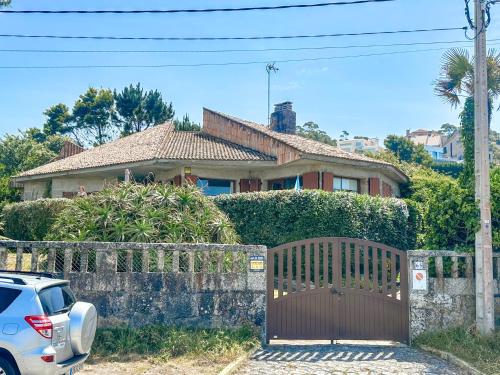 un coche aparcado frente a una casa con una puerta de madera en Villa Tomada Da Luz, en Areas