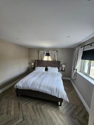 a bedroom with a bed with white sheets and pillows at Collooney - House - Sleeps 6 - Parking in Sligo