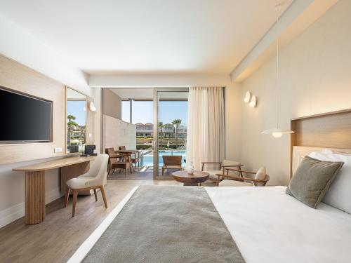 a hotel room with a bed and a desk at Avra Imperial Hotel in Kolymvari