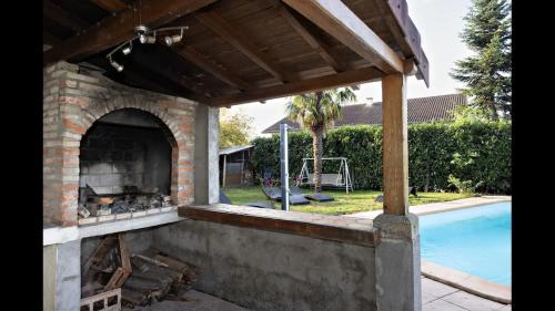 un four extérieur en briques avec une piscine en arrière-plan dans l'établissement Maison 6 chambres, piscine, grand jardin, à Saint-Marcel