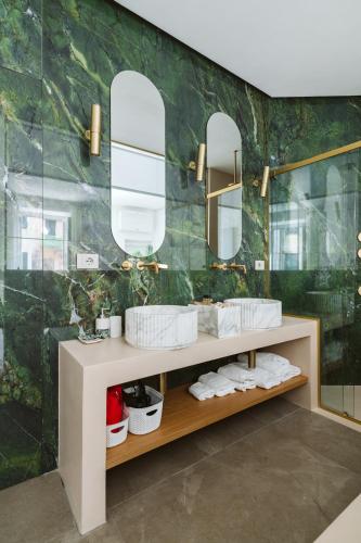 a bathroom with two sinks and two mirrors at Scarlet in Vernazza