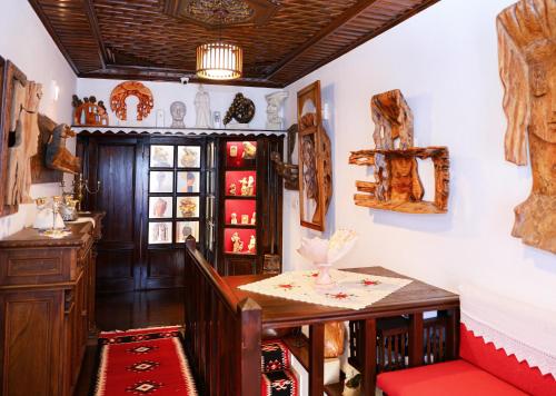 a dining room with a table and a shelf of dishes at Oda e Skulptorit-UNESCO quarter in Berat