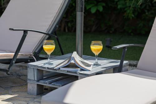 two wine glasses on a table with a book at Villa Ivona with pool in Poljica