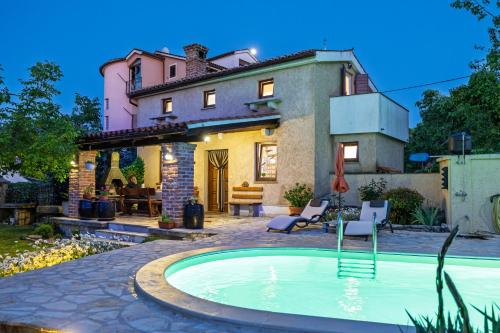 a house with a swimming pool in front of a house at Villa Ivona with pool in Poljica
