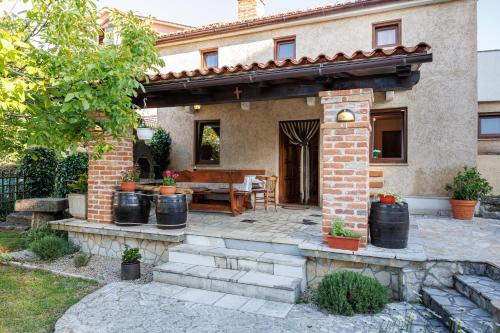 a house with a patio with a wooden table and a table at Villa Ivona with pool in Poljica