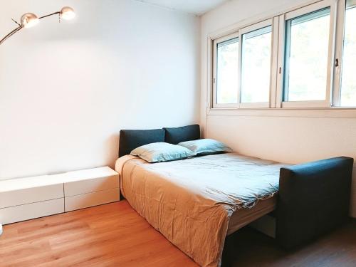 un lit dans une chambre avec une fenêtre dans l'établissement Studio avec piscine partagée Presqu'île de Saint-Mandrier-sur-Mer, à Saint-Mandrier-sur-Mer