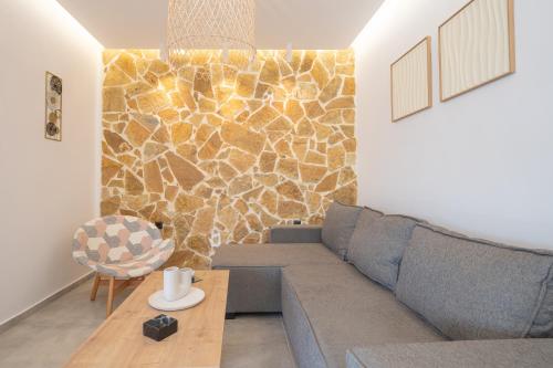 a living room with a couch and a stone wall at Stone and Sea Kos Retreat Serenity in (( Kermetés ))