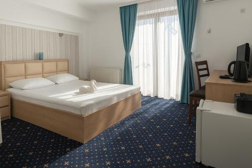 a bedroom with a bed with a white towel on it at Armsea Mamaia Nord in Mamaia Sat/Năvodari