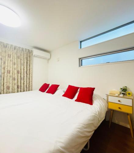 a bedroom with a white bed with red pillows at Alo BnB 5 - Near NIPPORI, SENDAGI, YANAKA GINZA, UENO - Self check-in in Tokyo