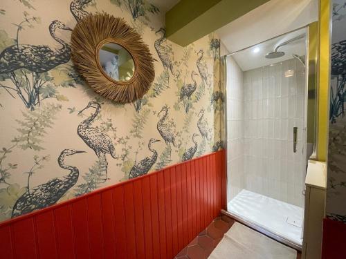 une salle de bains avec une fresque murale représentant des oiseaux. dans l'établissement Le Clos Vildor, maison de charme bordée par la rivière, à Canehan