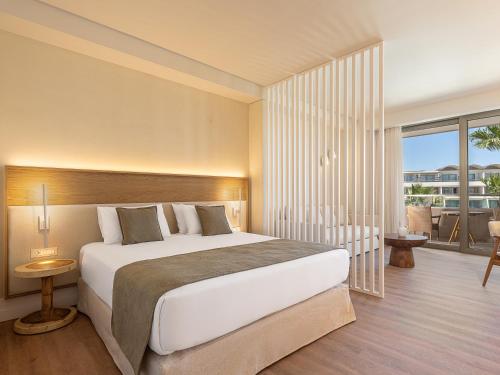 a bedroom with a large bed and a balcony at Avra Imperial Hotel in Kolymvari