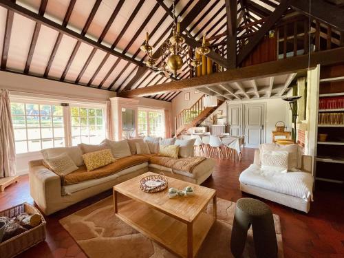 un salon avec un canapé et une table dans l'établissement Le Clos Vildor, maison de charme bordée par la rivière, à Canehan