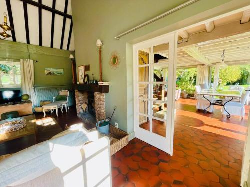 un salon avec une cheminée et une table dans l'établissement Le Clos Vildor, maison de charme bordée par la rivière, à Canehan