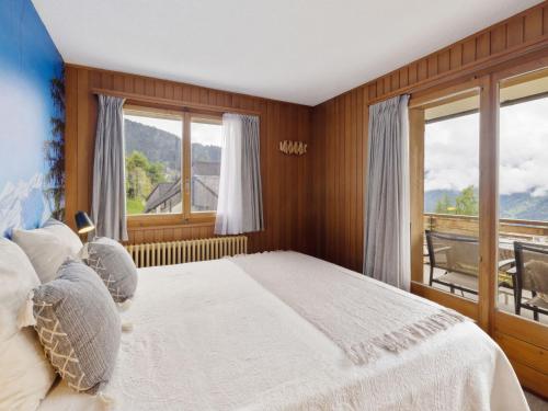 a bedroom with a large bed and a window at Apartment La Toura by Interhome in Verbier
