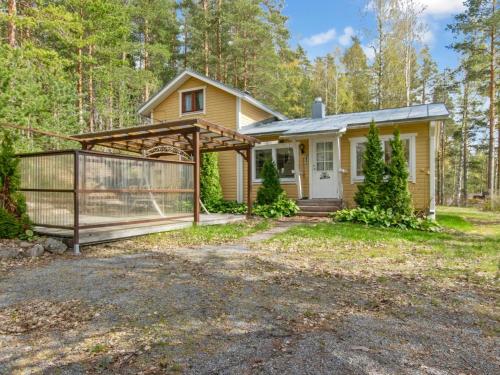a small yellow house with a wooden fence at Holiday Home Saunamäki by Interhome in Arpolahti