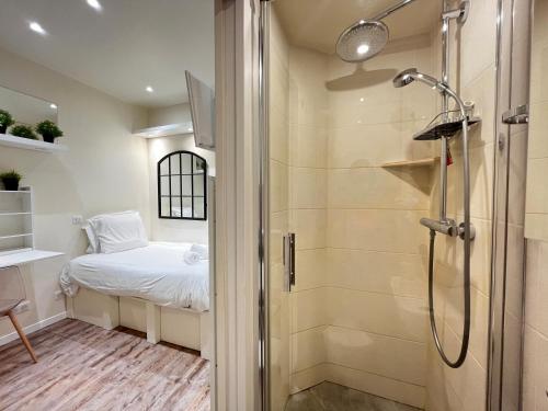 La petite salle de bains est pourvue d'un lit et d'une douche. dans l'établissement Studio Exceptionnel au Marais, à Paris
