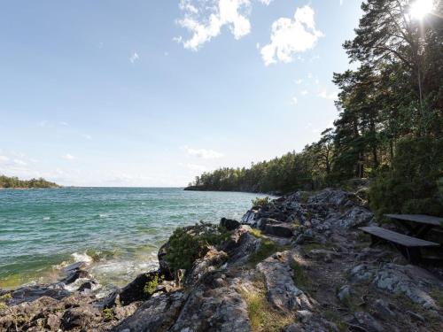 a bench on the shore of a body of water at Chalet Harge Sörgård by Interhome in Hammar