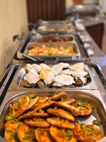 a buffet with several trays of food on a table at Best Western Premier Dynasty in Addis Ababa