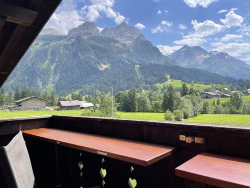 einen Balkon mit einer Bank und Bergen im Hintergrund in der Unterkunft Apartment Sonnegg by Interhome in Gsteig