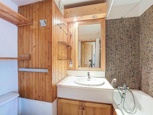 une salle de bain avec un lavabo, une baignoire et un miroir dans l'établissement Studio Chavière 832 by Interhome, aux Menuires