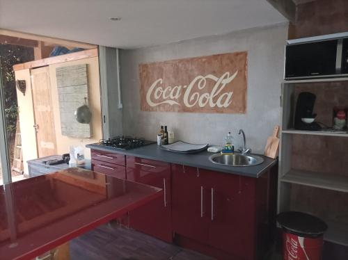une cuisine avec un panneau de cocacola sur le mur dans l'établissement Studio tout équipé, à Bédoin