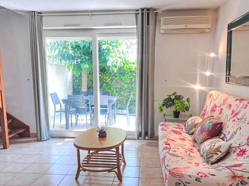 un salon avec un canapé et une table dans l'établissement Holiday Home Les Lavandines 1-6 by Interhome, au Cap d'Agde