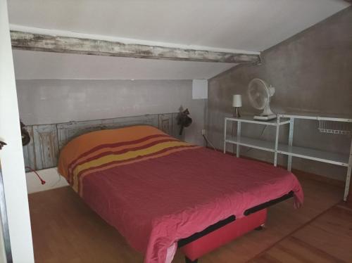 une chambre avec un lit avec une couverture rouge dans l'établissement Studio tout équipé, à Bédoin