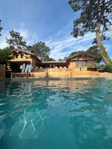 une piscine devant un complexe hôtelier dans l'établissement Magnifique maison à 20 m de la mer vue bassin, à Lège-Cap-Ferret