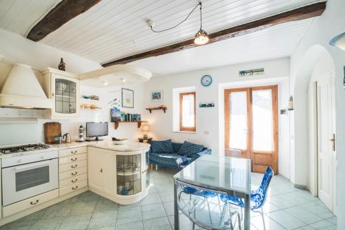 a kitchen and living room with a glass table at Perfume House in Marciana