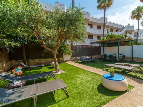 een achtertuin met een picknicktafel en een boom bij Villa Villa Rosa by Interhome in Port d'Alcudia