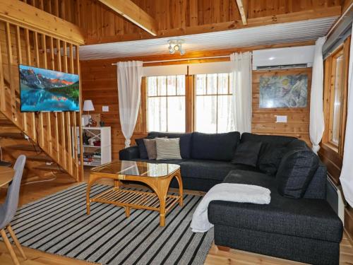 ein Wohnzimmer mit Sofa und Tisch in der Unterkunft Holiday Home Saukonpiilo 1 by Interhome in Pyhätunturi