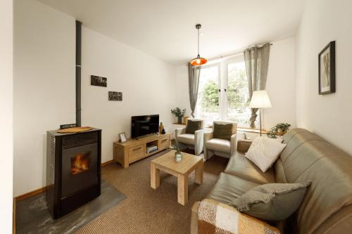 a living room with a couch and a fireplace at Äuchen am Rosenthal in Monschau