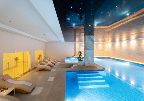 a swimming pool with lounge chairs next to a swimming pool at Pickalbatros Palais Des Roses - Agadir - All Inclusive in Agadir