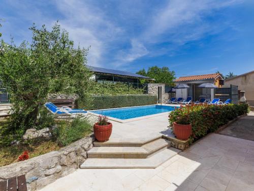 a swimming pool with chairs and a house at Holiday Home Starci by Interhome in Labin