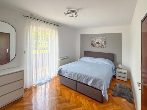 a bedroom with a bed and a large window at Apartment Cvjetko by Interhome in Rakalj