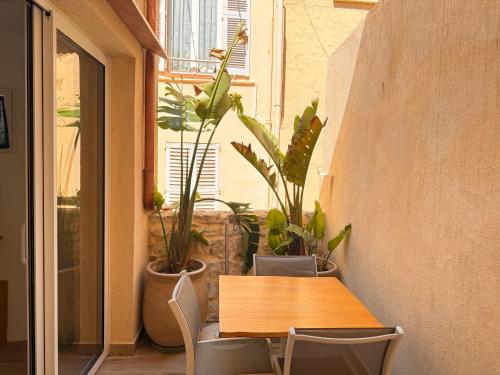 d'une table, de chaises et de plantes sur le balcon. dans l'établissement CB Cannes- NEW YORK, à Cannes