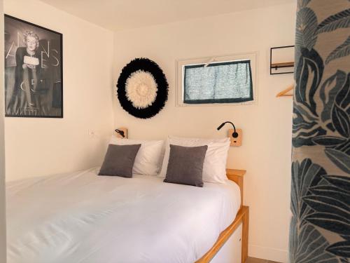 une chambre avec un lit avec des draps blancs et une fenêtre dans l'établissement CB Cannes- NEW YORK, à Cannes