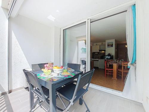 - une table à manger avec des chaises et une table avec de la nourriture dans l'établissement Studio La Frégate-9 by Interhome, au Grau-du-Roi