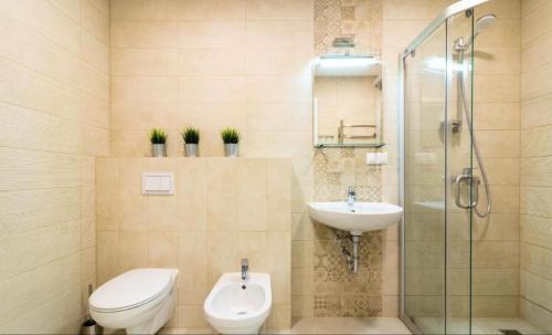 a bathroom with a toilet and a sink and a shower at Elija Swan-Toy Apartments in Šventoji