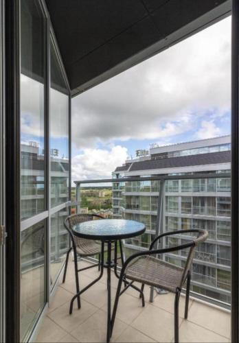 a balcony with a table and chairs on a balcony at Elija Swan-Toy Apartments in Šventoji