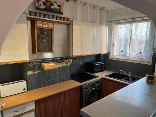 une cuisine avec un évier et une cuisinière four supérieur dans l'établissement Appartement, Canet-Plage centre, à Canet