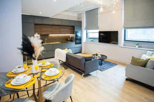 a kitchen and a living room with a table and chairs at Chic Manchester Chinatown Stay - Shops & Nightlife in Manchester