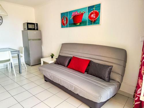 - un canapé avec un oreiller rouge dans le salon dans l'établissement Studio Le Village - C9 279 by Interhome, à Agay